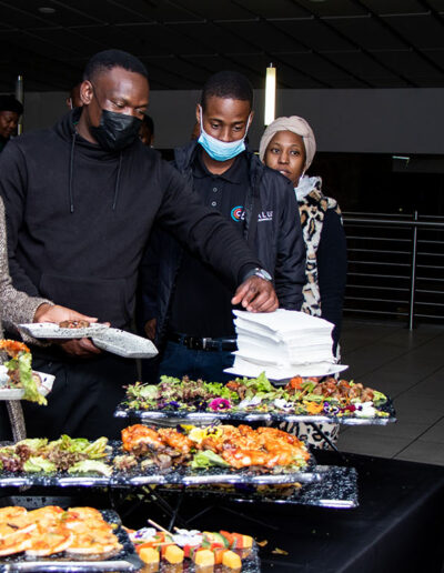 Guests lining up at a buffet with assorted hot dishes, highlighting variety in corporate catering services