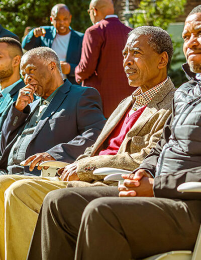 Elderly guests seated at a sunny outdoor event, showcasing relaxed atmosphere and expert event coordination