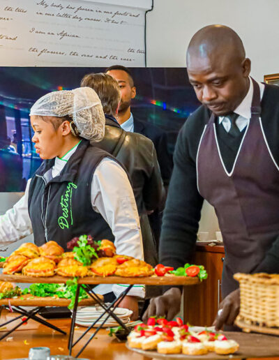 Catering staff preparing fresh platters at an indoor event, ensuring quality presentation and service delivery